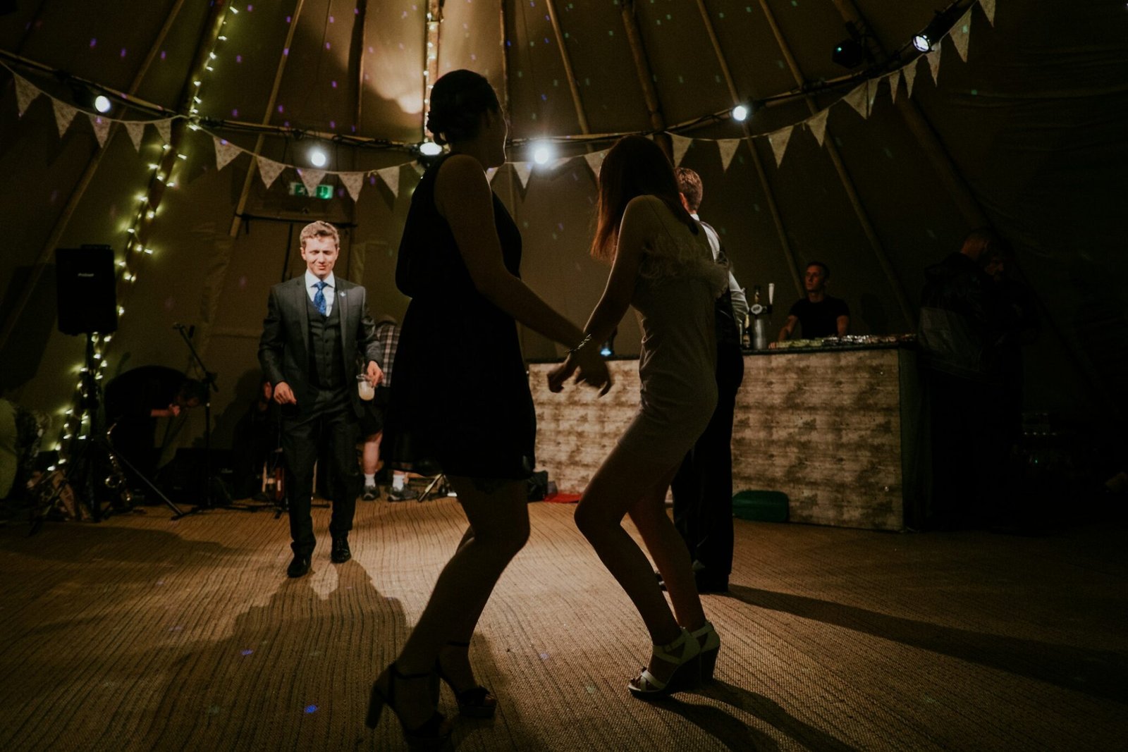 Couple dancing outdoors under festoon lights