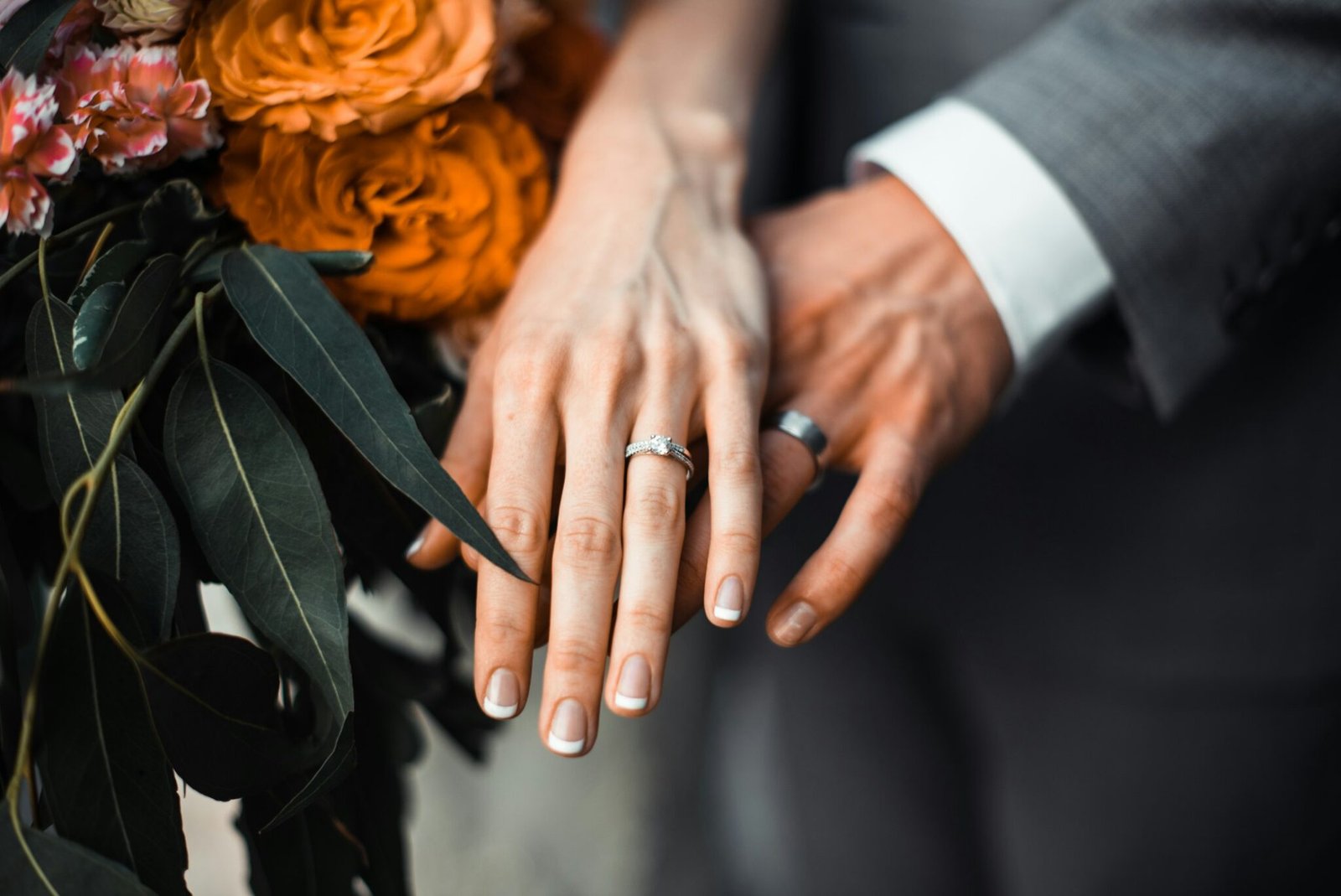Close-up of a couple’s hands wearing wedding rings