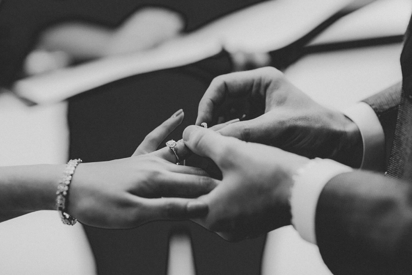 Black and white close-up of hands with a wedding ring