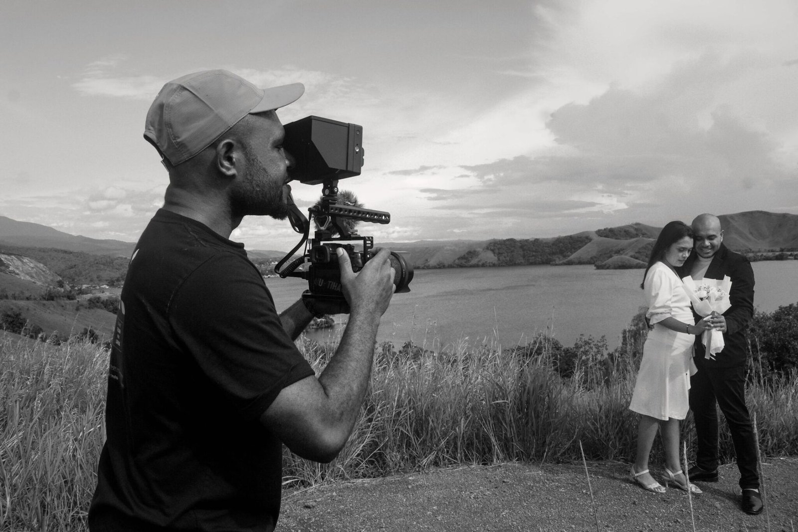 Black and white photo of a videographer holding a cinema camera